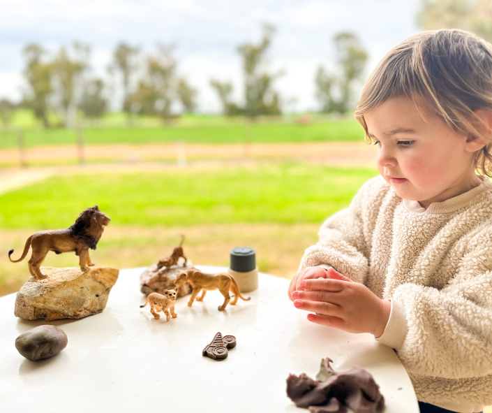The girl is playing with playdough and animals The girl is playing with playdough and animals
