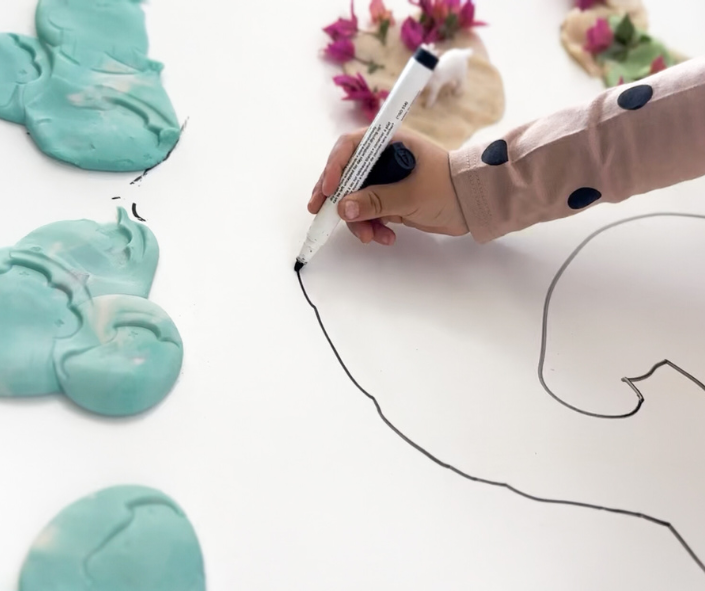 Child is drawing, holding a pencil in her hand The girl is drawing, holding a pencil in her hand